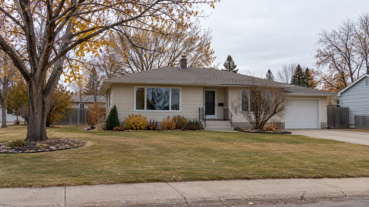 Autumn cleanup result at a modest Saskatchewan bungalow with dormant-season colour, tidy lawn and clean beds.
